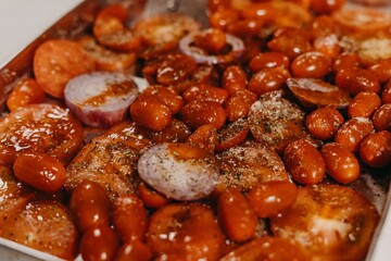 Closeup of a tray filled with tomatoes, peppers, onions with seasonings