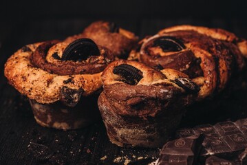 Chocolate pastries on a table, with crumbs and broken pieces scattered around the surface