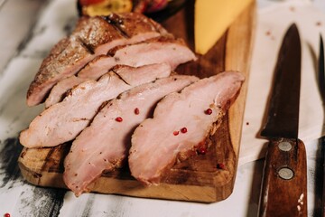 Closeup of freshly prepared meat and cheese slices on a cutting board