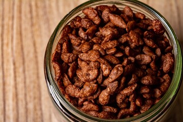 Top view of a jar with candied almonds on a wooden table
