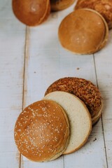 Vertical of the freshly baked and sliced bun breads put on the white table surface