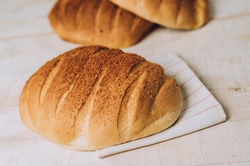 High angle of freshly baked crusty bread put on the white table surface