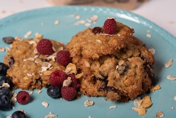 Close-up shot of oat cookies with berries on a blue plate