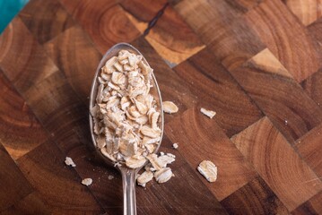 Top view close-up of a spoon with cereal on a wooden table