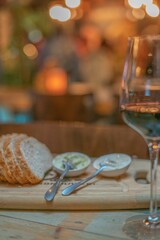 Glass of wine in background of bread slices on wooden board