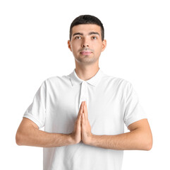 Fototapeta premium Young man in white polo shirt with hands in namaste gesture, spiritual practice and mindfulness