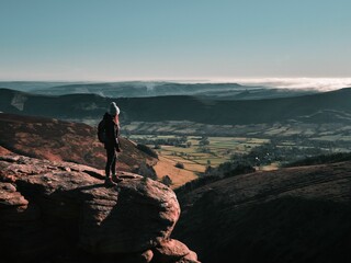 Female tourist standing on top of the Grindslow Knoll hill in England