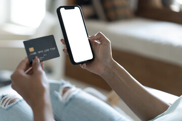 Close up of woman holding banking credit card, entering payment information in smartphone application, transparent screen