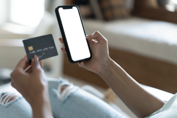 Close up of woman holding banking credit card, entering payment information in smartphone application, transparent screen