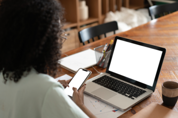 Female person sitting front open laptop computer and smart phone with transparent blank empty screen for your information or content