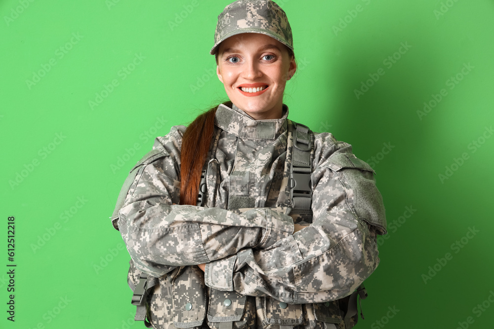 Wall mural Female soldier in military uniform on green background