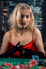 Young woman wear red evening dress playing poker at casino