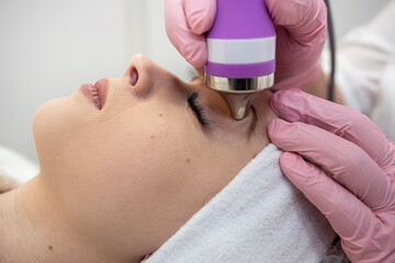 Cosmetologist doing ultrasound skin on face  tightening for rejuvenation at spa