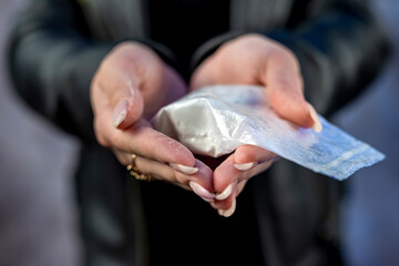 female hand holds bag with cocaine for sale