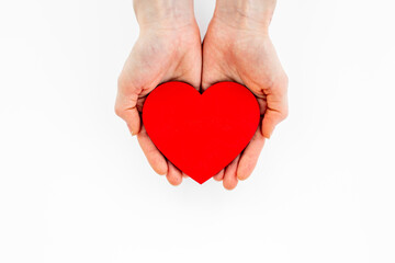 Obraz premium Woman holding red heart in hands. Medical insurance or health care concept