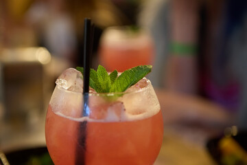 Pink summer cocktail with mint leaf and rum served for a party on a bar stand. Enjoy refreshing...