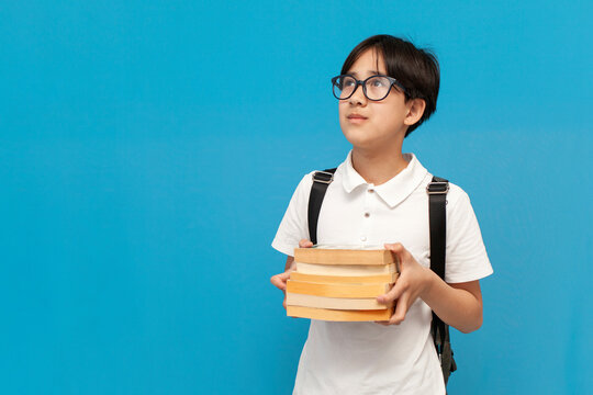 Asian Boy Schoolboy Of Twelve Years Old Wearing Glasses And With Backpack Holds Lot Of Books