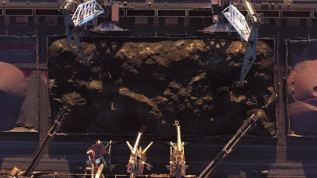 Top view of working sea port cranes. Piles of black coal.