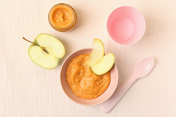 Bowl of apple baby puree on light background