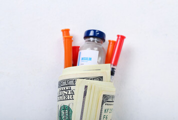 Insulin with syringes and money on white background, closeup. Expensive medicine concept