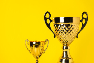 Gold cups on yellow background, closeup