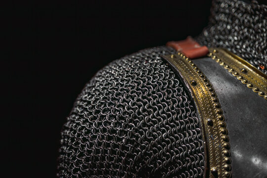 Close-up and texture of a chain of handmade real chain mail armor, authentic armor of a medieval knight on a dark background, selective focus