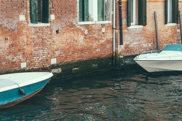 Fototapeta na wymiar Picturesque idyllic scene with a boat parked on the water canals in Venice, Italy.