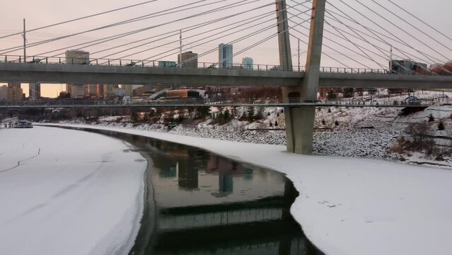 Beautiful drone view of the Tawatina Bridge over the partially frozen river in Edmonton, Alberta