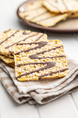 Puffed corn crackers chocolate covered on white table.