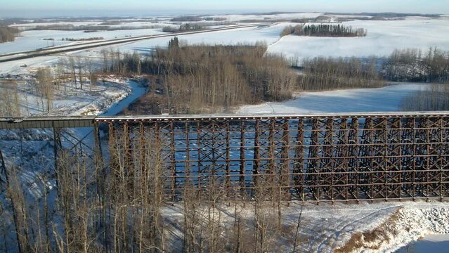 Aerial footage of the Rochfort Trestle Bridge in Alberta, Canada in winter