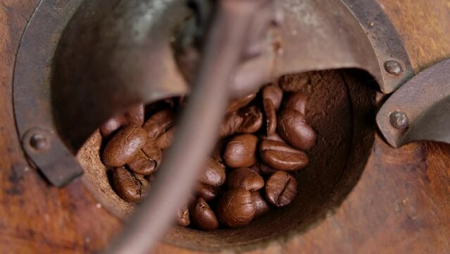 Close-up of the coffee beans grinded in the retro vintage coffee miln
