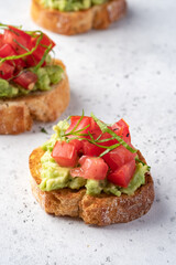 Bruschetta with tomato, mashed avocado and herbs