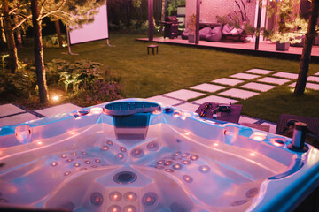autonomous hot tub or jacuzzi with hot water and evening lighting