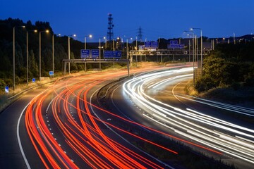Fototapeta na wymiar Night time traffic speeds past a junction on the M5 motorway near Bristol, UK