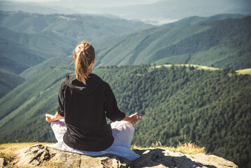 Young woman on the top of mountain