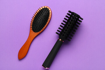 Hair brushes on violet background