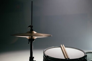 Fototapeta na wymiar A close up of a drum set with drum sticks. The background is dark.
