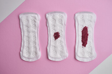 Menstrual pad with red sequins on a pink background. The period of the menstrual cycle, feminine hygiene. Women's health concept