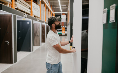 building materials stores a man chooses doors to his new apartment