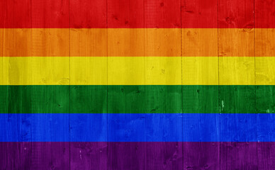 Flag of the LGBT community on the background of the wooden texture of the boards. Rainbow gay culture symbol. Concept collage.