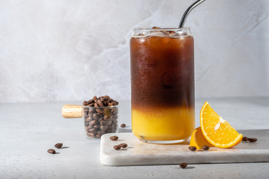 Bumble coffee mix with orange juice and cold brew coffee with ice. Summer trendy refreshing coffee drink.