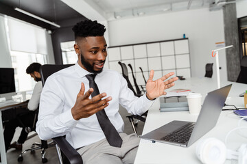 Young african american man using laptop while working at office