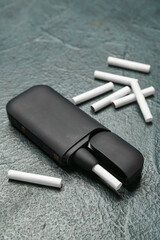 Modern electronic cigar with sticks on dark grunge table
