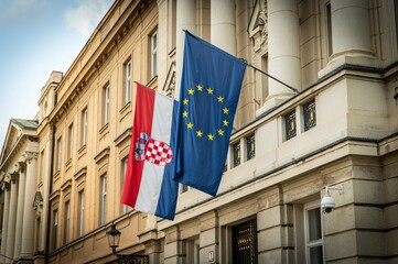 Croatian and EU flags hanging outside the Croatian Parliament Palace in Zagreb, Croatia