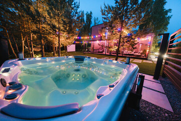 autonomous hot tub or jacuzzi with hot water and evening lighting - obrazy, fototapety, plakaty