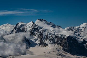Obraz premium Beautiful shot of snowy mountains against a blue sky on a sunny day