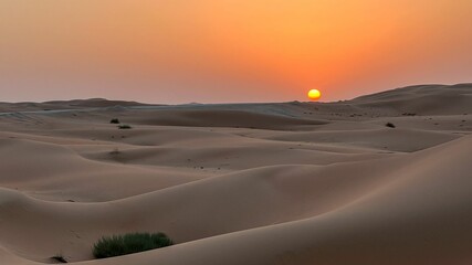 Fototapeta na wymiar Beautiful scenery of an orange sunset over the desert