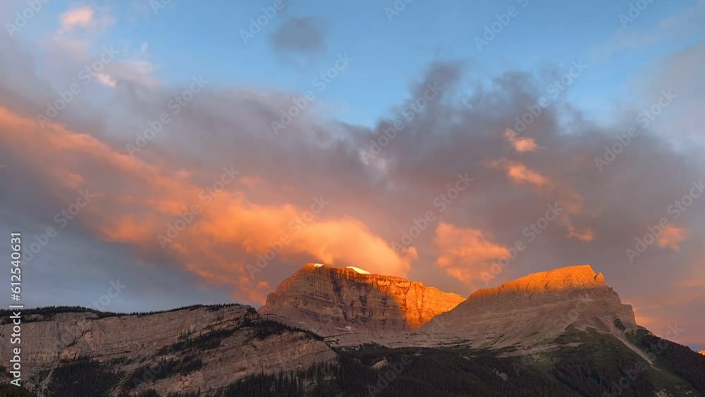 Poster time lapse footage of clouds above a rocky hills at sunset