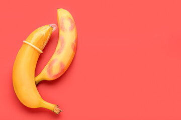 Bananas with lipstick kiss marks and condom on red background. Sex concept