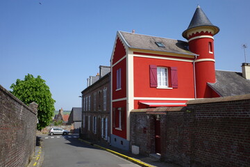 Street with a brick wall and a red house in Saint-Valery-sur-Somme, France